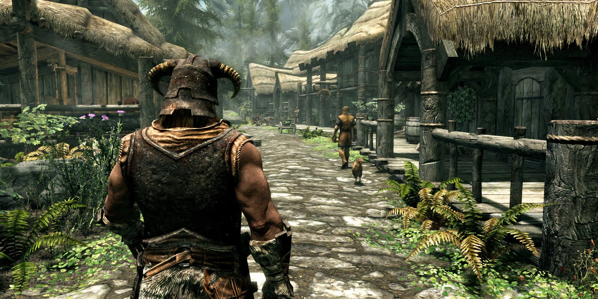 Nhân vật chính Skyrim Anniversary Edition nhìn từ phía sau trong khung cảnh làng mạc và núi non hùng vĩ